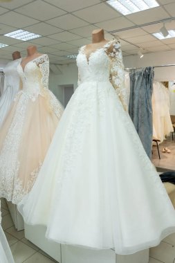 Beautiful wedding dresses in a bridal boutique on mannequins.