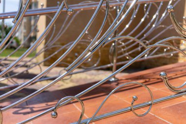 Decorative railing made of stainless metal close-up.