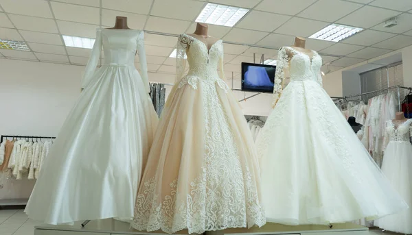 Three chic wedding dresses on mannequins. Three different models of beautiful wedding dresses.