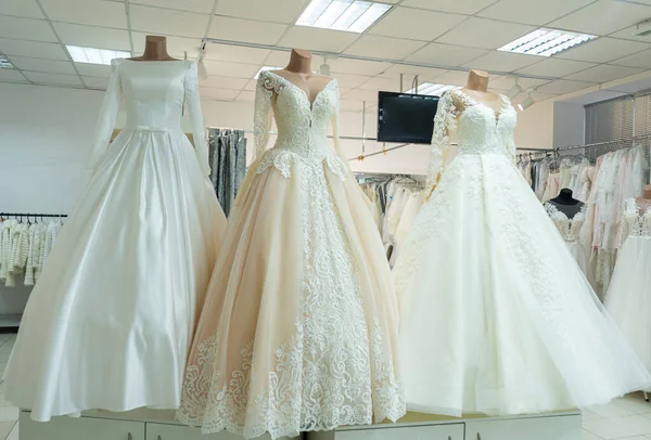 Three chic wedding dresses on mannequins. Three different models of beautiful wedding dresses.