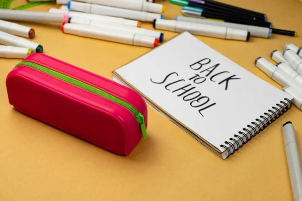 Back to school is written in black marker on a white notebook. School background. School supplies are prepared for school.