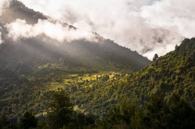 Cunta Vadisi 'nin tepeleri güneş ışınlarıyla aydınlatılmış bulutların arasından süzülüyor. 
