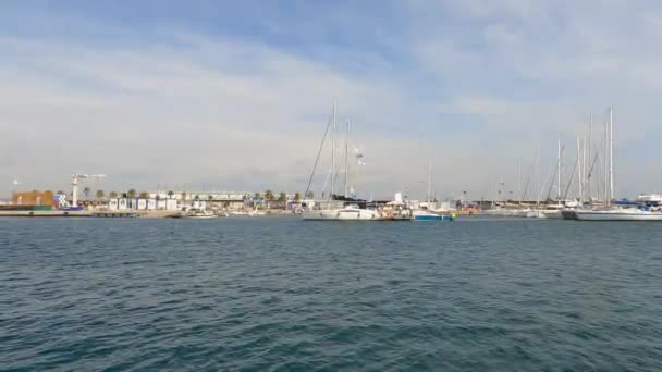 西班牙瓦伦西亚 2021年3月10日 船只和帆船停泊在瓦伦西亚的码头上 在阳光灿烂的日子里 船旗在大风中飘扬 小浪花在海里飘扬 — 图库视频影像