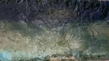 4K video yavaş çekimde bir çeşmeden akan suyun üzerinden bir bloğun içinden geçen ve bazı kayaların üzerine düşen anaforlar ve kabarcıklar oluşturan bir şelale.