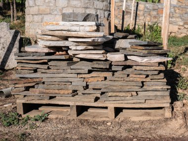 Kırsal bir evin şantiyesi için ahşap bir palette mükemmel bir denge sağlayarak yığılmış ve istiflenmiş bloklar.