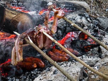 Kaya barbeküsü tarlada ahşap kütükler, çubuklara saplanmış pastırma şeritleri doğrudan küllerin üzerine konmuş közler, sosisler ve biberler ile yapılır.