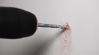 4K yavaş çekim videosu, duvarda matkapla delik açan bir adam ve çekiç kullanarak deliğe bir panel sokan eldivenli bir adam.