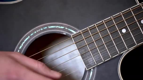 Vídeo Close Mão Homem Dedilhando Cordas Uma Guitarra Acústica Preta — Vídeo de Stock