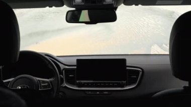 Arabanın ön camını temizleyen bir adamın 4K videosu. Arabanın içinde basınçlı sabun ve su var.