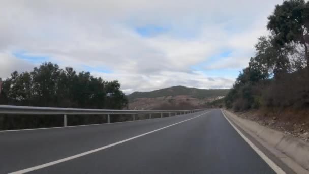 道路两旁有湿湿的沥青和警示牌 一天内有大积云的车辆通过别尔佐山脉的示踪曲线的主观视图 — 图库视频影像