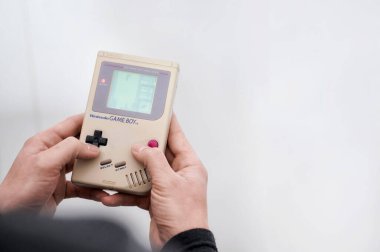 Madrid, İspanya; 04-04-2022: Popüler oyun Tetris oynarken elinde klasik bir video oyunu tutan adam