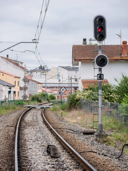High railway entrance (E1) sign at the Monforte de Lemos station indicating a stop in red on its lamp and the ASFA beacon at the foot of the associated signal located between the rails of the track