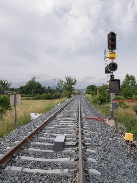 High railway signal for the E2 entrance to the Monforte de Lemos station indicating a stop (Red) and a yellow sign indicating 