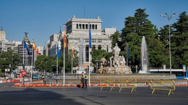 Madrid, Spain; 06-29-2022: Flag of Spain and NATO waving together in the Plaza de Cibeles in Madrid on the occasion of the summit organized in the city and police controlling security clipart