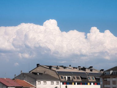Cumulus clouds move towards the city of Monforte de Lemos, approaching a storm in its lower part over the buildings of the town