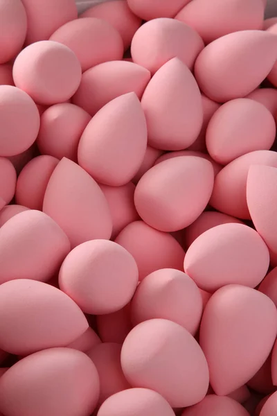 Beauty background a bunch of pink gentle makeup sponges vertical orientation — Stock Photo, Image