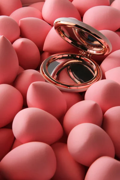 Beauty background a bunch of pink gentle makeup sponges and a mirror vertical orientation — Stock Photo, Image