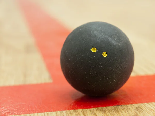 Черный мяч для сквоша на лине — стоковое фото