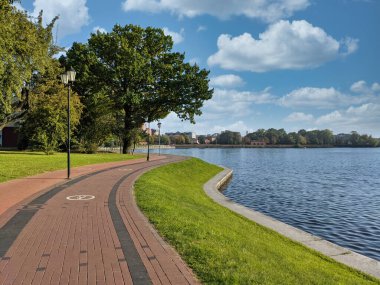 Çimenler, Yukarı Göl 'ün setinde boş yaya geçidi ve bisiklet yolu. Gündüz vakti Rusya' nın Kalininingrad şehrinde yapay şehir havuzu, turistik eğlence ve popüler eğlence bölgesi. İnsansız..