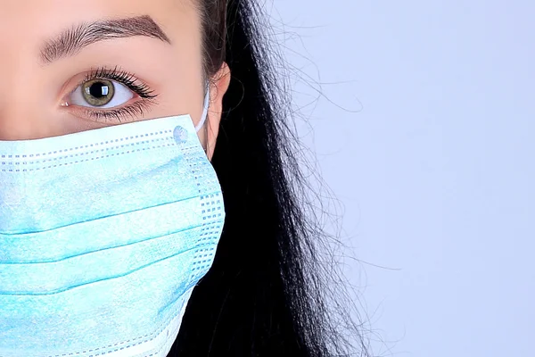 bir kadın doktor cerrahın mavi tıp maskeli yüz yarısı