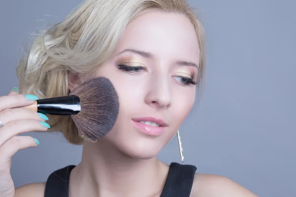 Makeup artist applying face powder