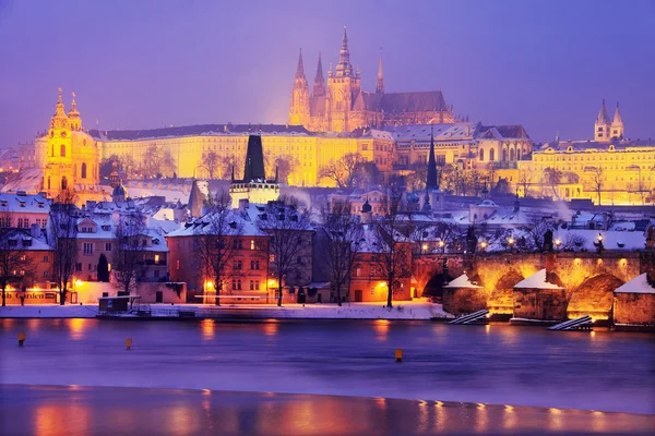 Νύχτα πολύχρωμο χιονισμένο γοτθικό κάστρο της Πράγας με τη γέφυρα του Καρόλου, Τσεχία — Φωτογραφία Αρχείου