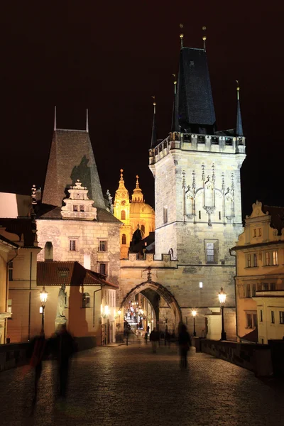 Night Prague St. Nicholas 'Cathedral med Charles Bridge, Tjekkiet - Stock-foto