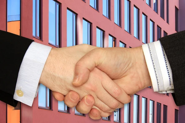 Biznesmeni drżenie rąk przed nowoczesnym budynku — Zdjęcie stockowe