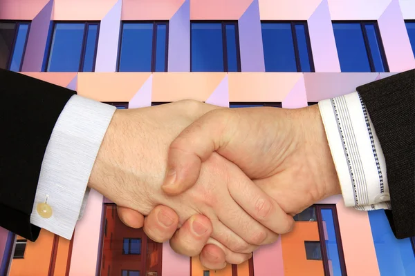 Businessmen shaking hands in front of the modern Building — Stock Photo, Image