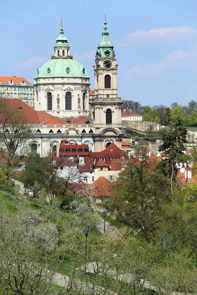 View on the spring Prague St. Nicholas' Cathedral with the green Nature and flowering Trees, Czech Republic — Stock Photo, Image