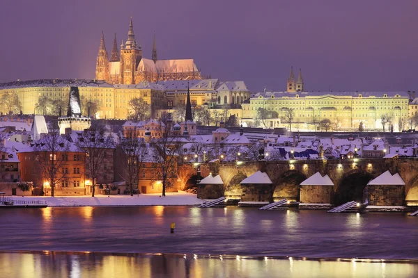 Nacht kleurrijke besneeuwde gotische burcht van Praag met charles bridge — Stockfoto