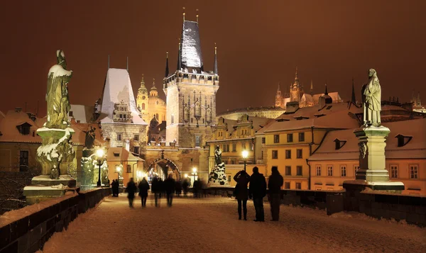 Night snowy Prague gothic Castle and St. Nicholas' Cathedral from Charles Bridge, Czech republic — Stock Photo, Image