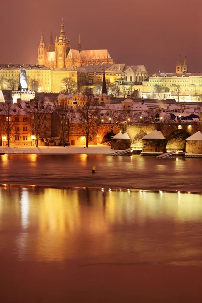 Natt färgglada snöiga gotiska Pragborgen med charles bridge, Tjeckien — Stockfoto