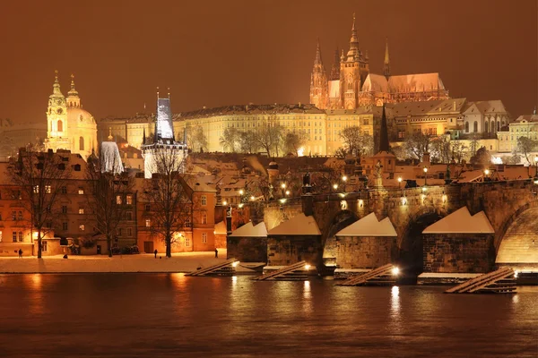 Natt färgglada snöiga gotiska Pragborgen med Karlsbron — Stockfoto