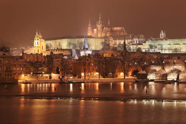 Nacht romantische besneeuwde Praagse gotische burcht en de st.-Niklaaskathedraal, Tsjechië — Stockfoto