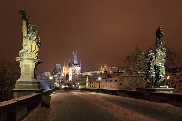 Ночной снежный Пражский готический замок и Николаевский собор из Карлова моста, Чехия — стоковое фото