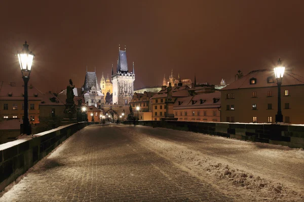 Snowy nocy Pragi gotyckiego zamku i katedry Świętego Mikołaja od charles most, Republika Czeska — Zdjęcie stockowe