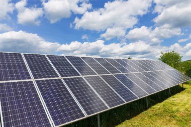 Güneşli, bulutlu bahar doğasında güneş enerjisi istasyonu.