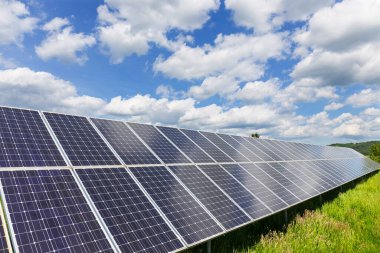 Güneşli, bulutlu bahar doğasında güneş enerjisi istasyonu.