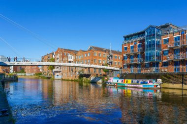 Renkli bir devlet mavnası, Leeds, West Yorkshire, İngiltere, İngiltere ile Nehir Havası 'nı kapsayan kablo destekli yaya köprüsü (yaya köprüsü).
