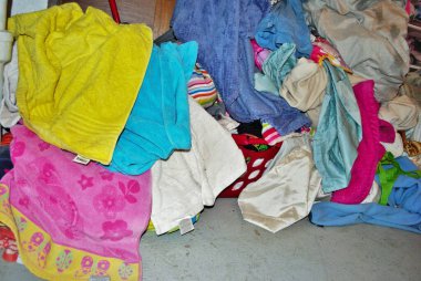 Bodrum katındaki çamaşır odasında yıkanması gereken bir yığın kirli havlu.