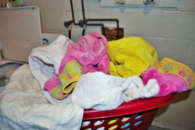 Çamaşır odasında yıkanması gereken bir sepet dolusu kirli havlu.