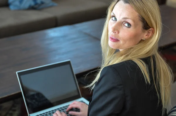 Eine junge Geschäftsfrau mit einem Laptop lizenzfreie Stockfotos