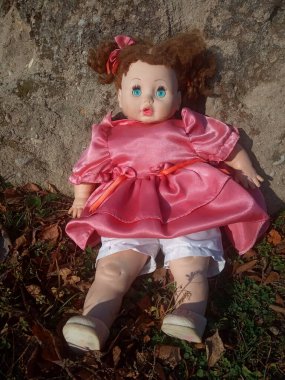 Güzel pembe bir elbise içinde gereksiz bir oyuncak bebek. 