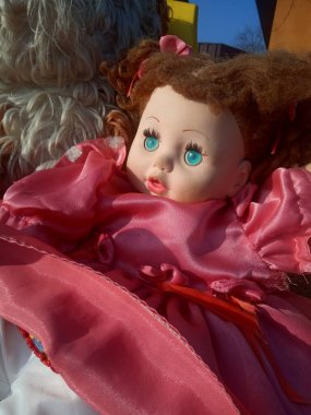 Güzel pembe bir elbise içinde gereksiz bir oyuncak bebek. 