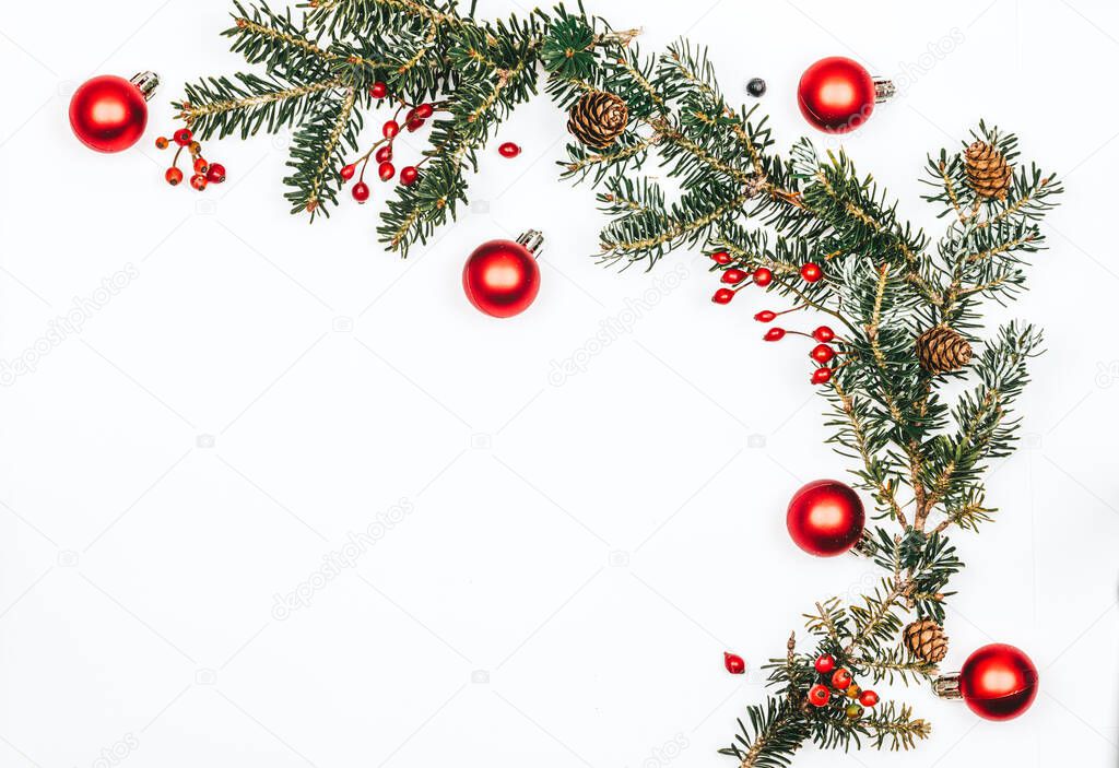 Natural pine branch with toys and red berries on a white background. Christmas background