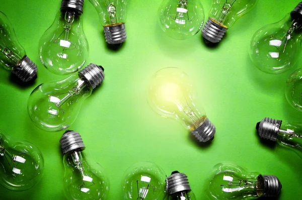 Glödlampor på grön bakgrund. — Stockfoto