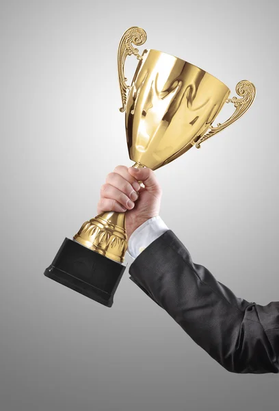 Empresário segurando um troféu dourado campeão — Fotografia de Stock