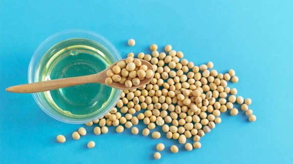 soybean and oil in a bowl on blue background, top view, flat lay, top-down, selective focus.copy space.