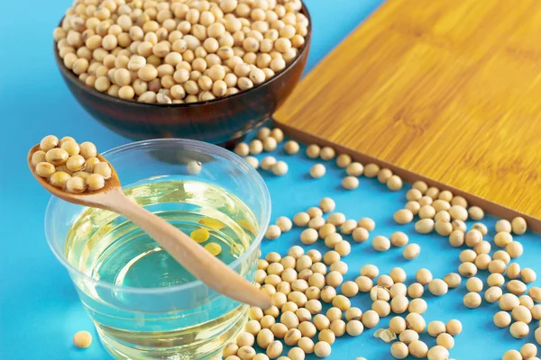 soybean and oil in a bowl on blue background, selective focus.copy space.front view.